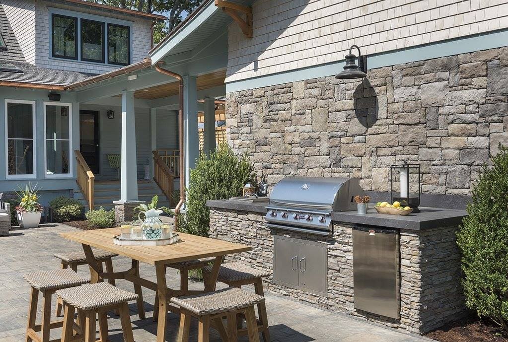 Built-in outdoor kitchen with stone counter and grill